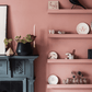 Living room floating shelves on pink wall